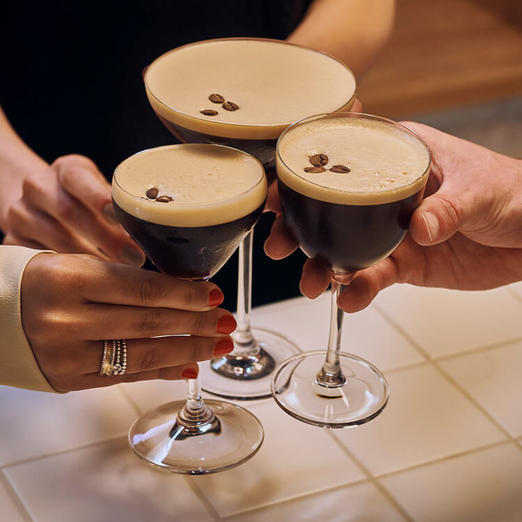 Two people standing next to two espresso martinis